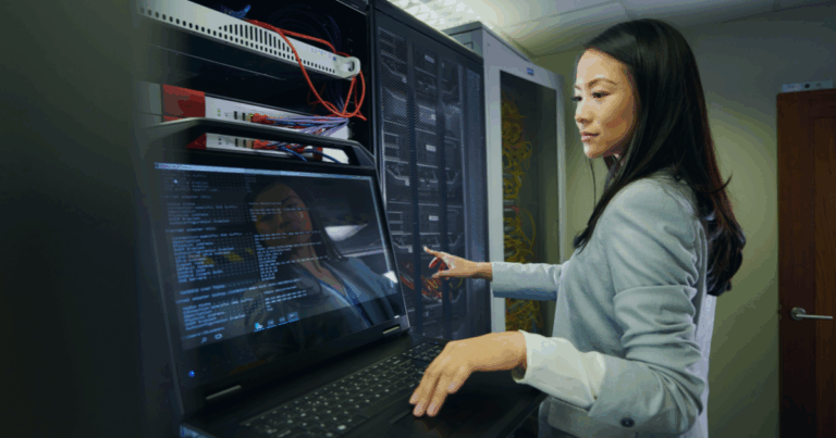 Engineer operating computer hardware while analyzing data on a connected monitor.