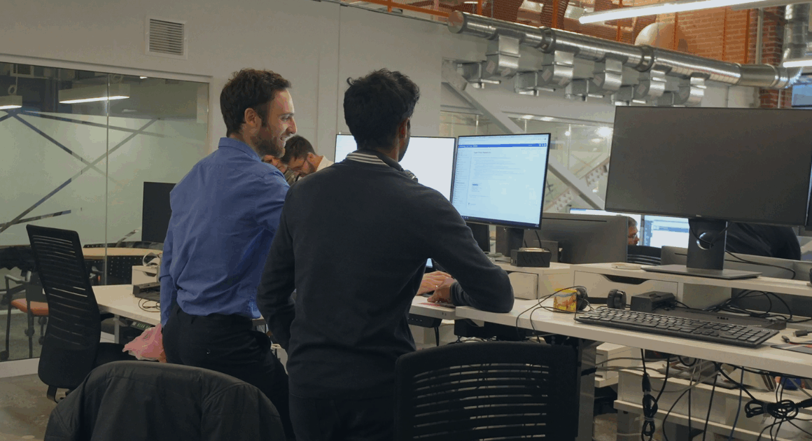 Two OPAL-RT engineers collaborating at computer monitors while testing real-time power system simulations.